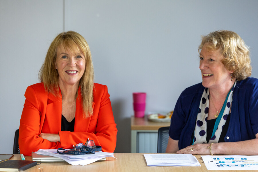 Karyn McCluskey and Catherine Dyer in conversation at a board meeting