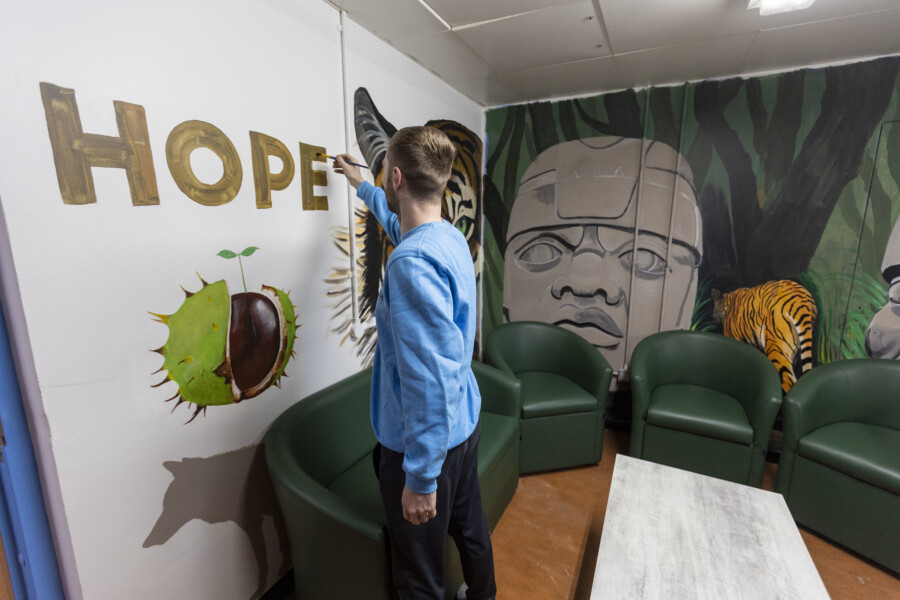 A wellbeing area in Perth Prison. The word 'HOPE' is written large on the wall and is surrounded by other imagery including a jungle scene and an acorn.