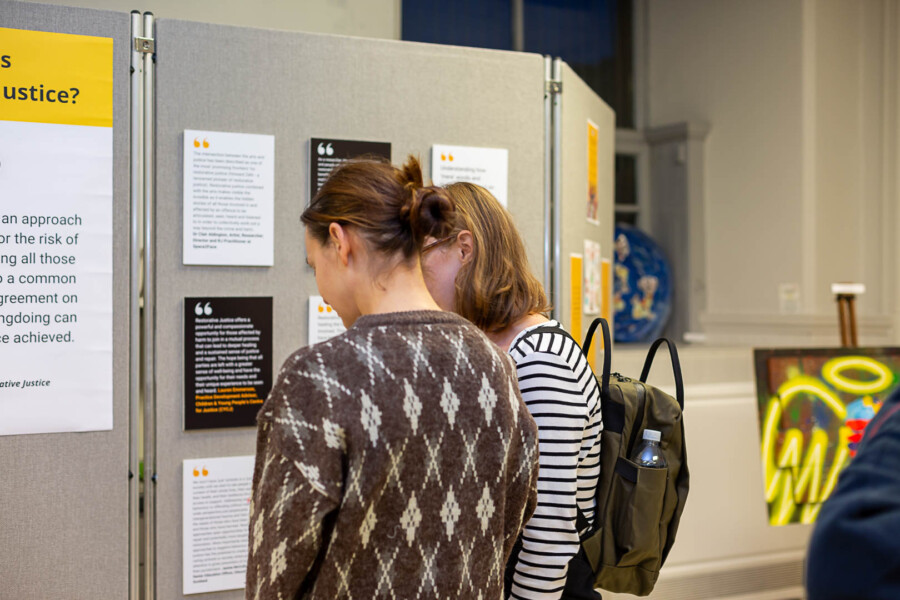 Two people looking at and reading information on a display board 