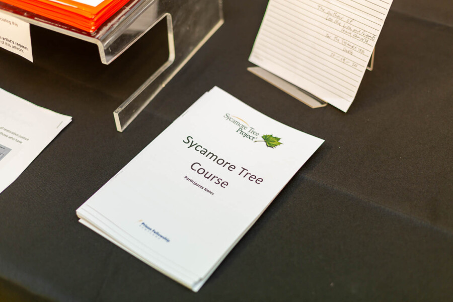 A table with booklets laid out. The booklet is called 'Sycamore Tree Course'