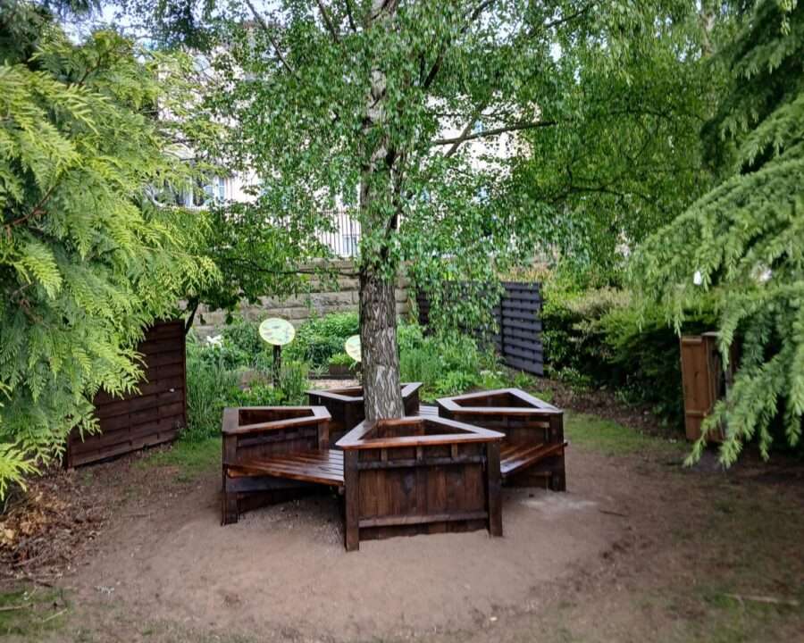 Circular bench with planters in a leafy park